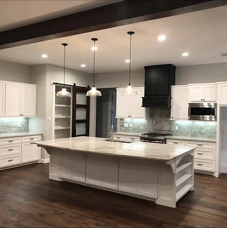 White kitchen with island pendant lighting and recessed can lights wired by Lowe Home Electric