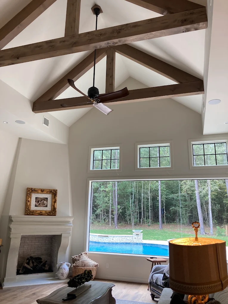 Vaulted living room with a ceiling fan and recessed lighting installed on wood trusses